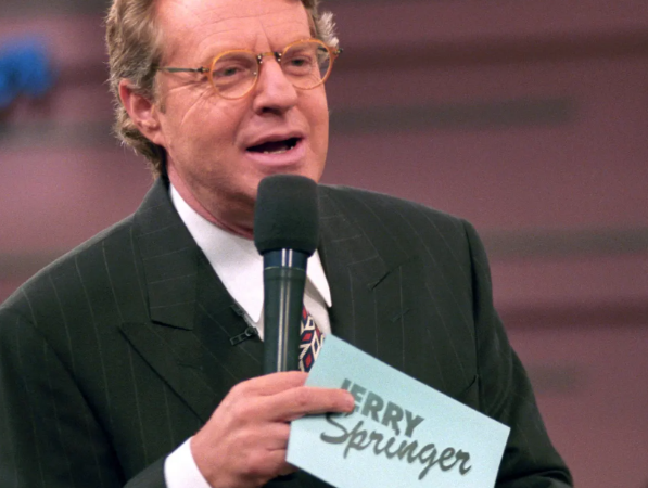 Jerry Springer with a microphone hosting his show
