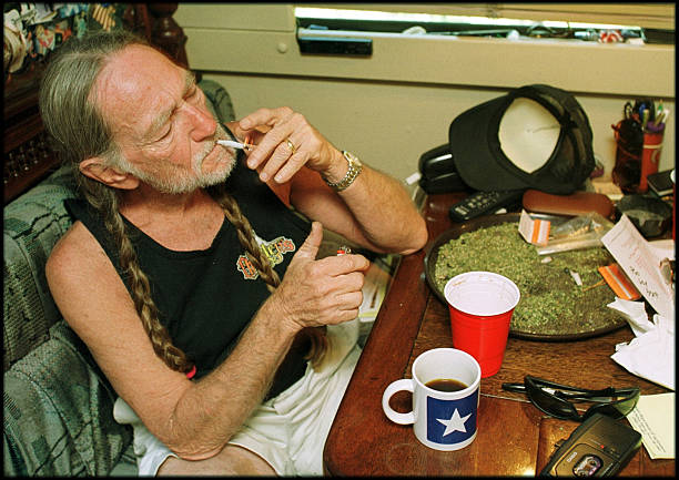 Willie Nelson at home lighting up a joint