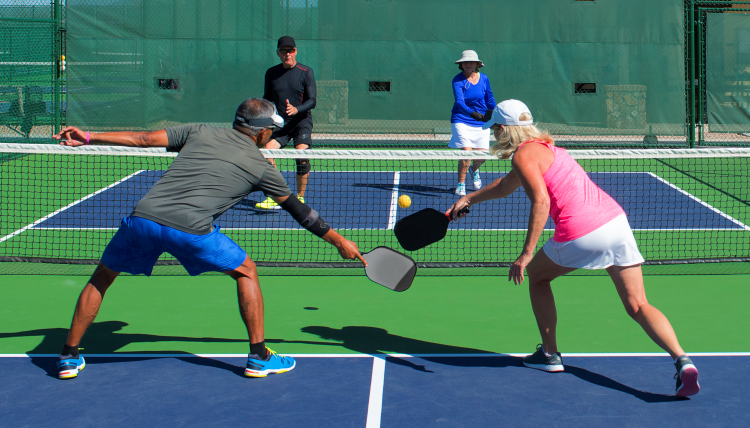 two pairs of seniors playing pickleball