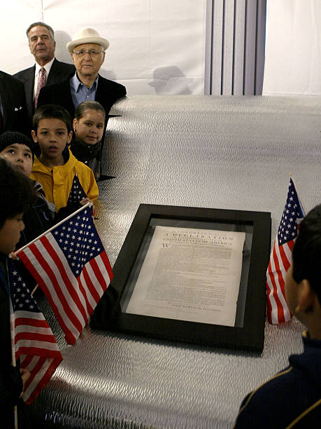 Norman Lear pictured with a group of kids with his Declaration of Independence that he owns.