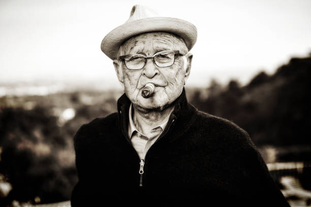 Black and white picture of an older Norman Lear with a cigar.