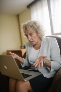 Picture of a woman looking confused sitting in front of her computer.