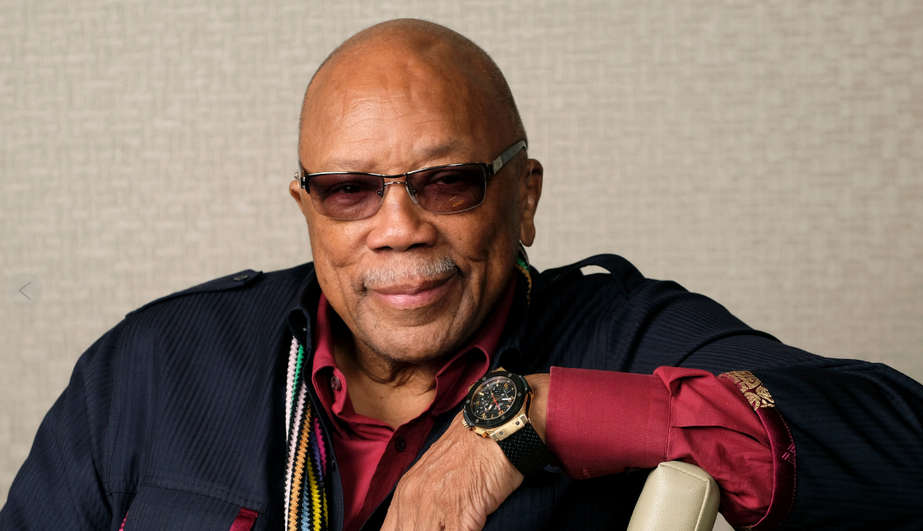 Quincy Jones sitting with a smile for the camera.