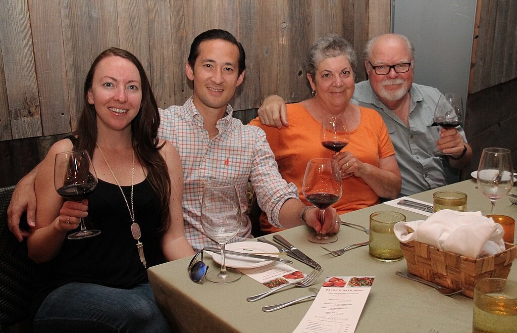 A group of people sitting at a table enjoying a glass of wine and each other.