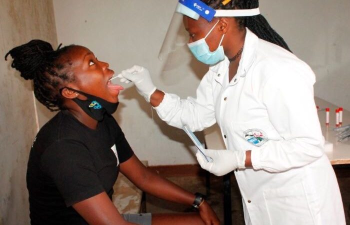 A doctor taking a swab from a younger patient.