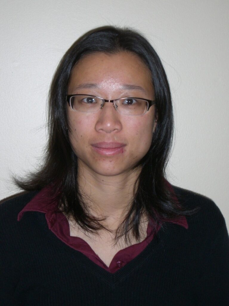 A head shot of a person with long hair and glasses.