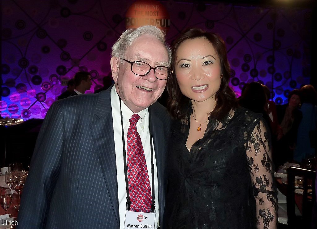 Warren Buffet taking a picture with a business woman.