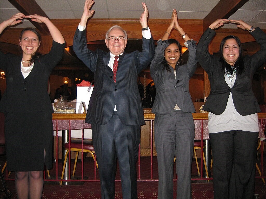 Warren Buffet celebrating with three other business woman.