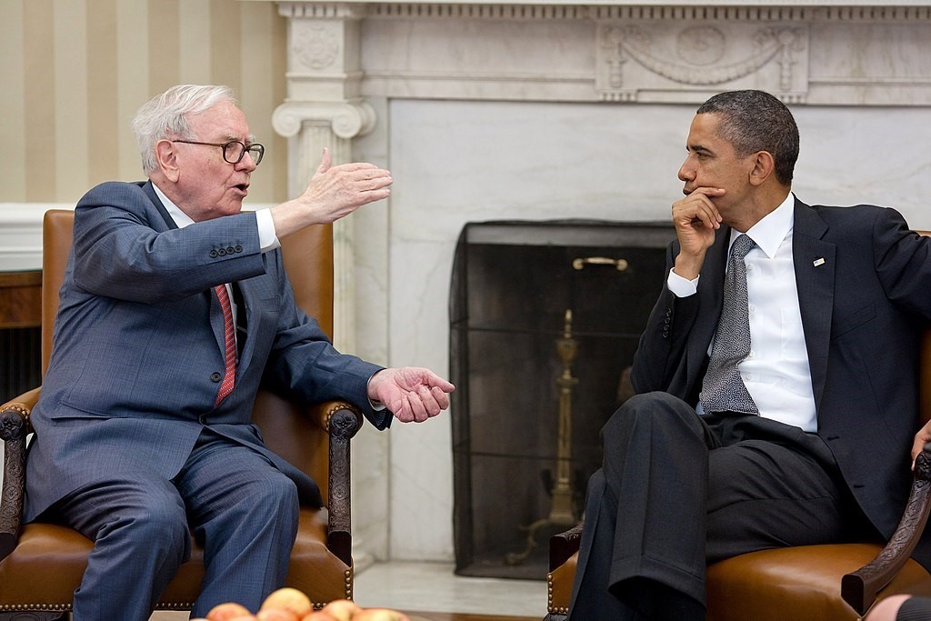 Warren Buffet sitting and talking with then president Obama.