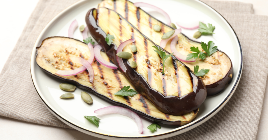 Eggplant slices arranged on a plate with herbs and light seasoning, served as a simple eggplant salad