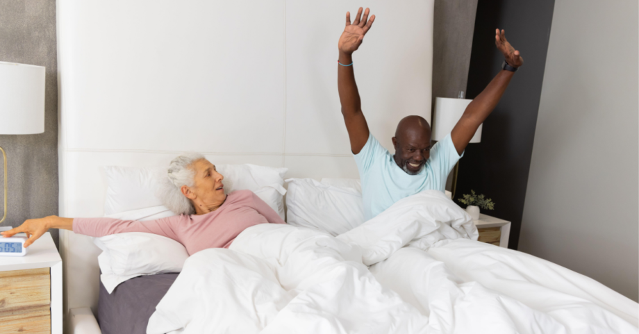 Older couple waking up refreshed in bed after a good night's sleep.